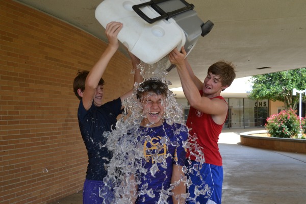 COOLING OFF -- Cross country members Jordan Brown and Chase France help fellow runner Jared Eddy in his ALS Ice Bucket Challenge.