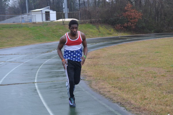 RUNNING IN THE RAIN -- Xavier Norwood trains for the 400 meter dash.