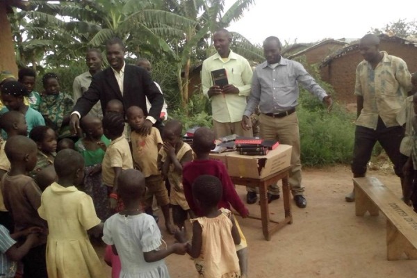 DISTRIBUTING HOPE -- Children in the Nakivale Refugee Camp eagerly await receiving a Bible.