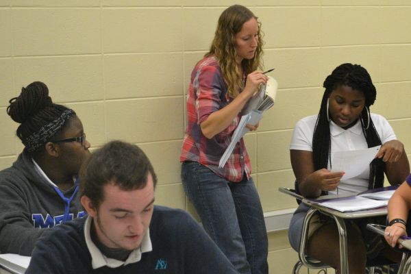 MRS. MIELKE GETS COMFORTABLE WITH CENTRAL MATH STUDENTS -- Mrs. Mielke works with students Brandon Jonhson (front left), Arteisha Cole (back left), and Ja Canna Boozer (right). 