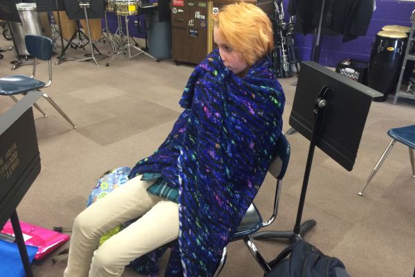 CENTRAL STUDENTS BUNDLE UP TO STAY WARM -- Georgia Teems wraps herself up in the band room to avoid the cold. 