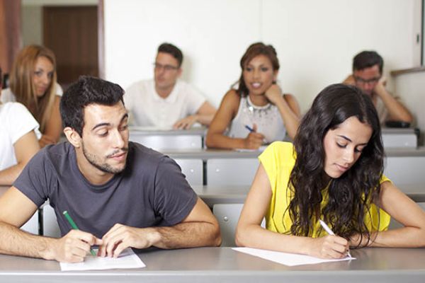 HIGH SCHOOL STUDENT CHEATING ON A TEST  -- Male high school student looks off of his fellow peers test