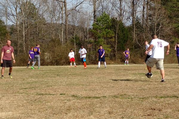 NEW SOCCER COACHES GET DOWN AND DIRTY SCRIMMAGING WITH THEIR TEAM -- Assistant Coach Jimmy Lessentine (left) and Head Coach Tim Browder (right) scrimmage with the boys to switch up the competition at practice. 