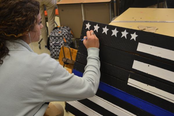 CENTRAL ART PROJECT COMMEMORATES FALLEN POLICE OFFICERS-- Gwendolyn Sofield, Central senior, shows respect for fallen police officers by painting project entitled "The Thin Blue Line."