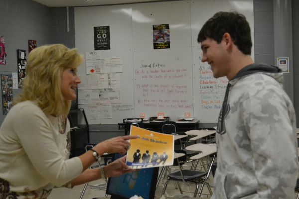 STEM TRIP FOR SENIORS -- Mrs. Holingsworth gives the job shadowing trip flier to  Johnathan Alston.