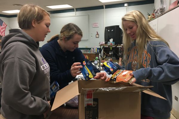 NATIONAL HONOR SOCIETY HELPS SOLDIERS -- Seniors Brooke Parrott, Lauren Reively, and Kymmy Stacks help pack treats for the soldiers.