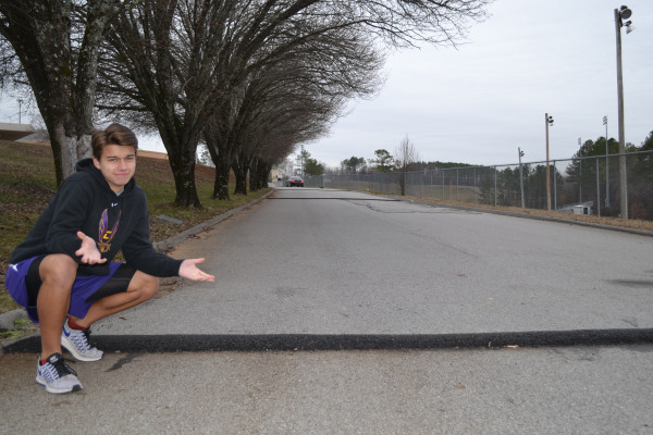 SPEED BUMPS EVERYWHERE -- Columnist Jared Eddy stands next to new speed bump at Central High.