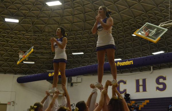 CHEERING ON THE POUNDERS -- Anahi Colunga (left) and Katee Herron (right) cheer on the purple pounders at a basketball game. 