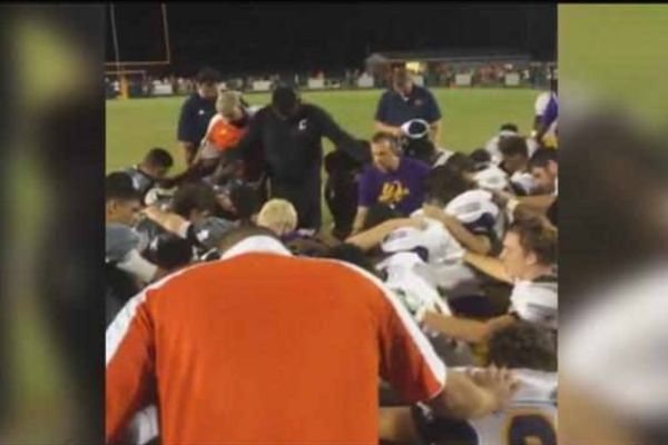 BUT SERIOUSLY:  WHEN CAN WE PRAY? -- Football players from Central and East Ridge players pray over an injured Central  athlete. 