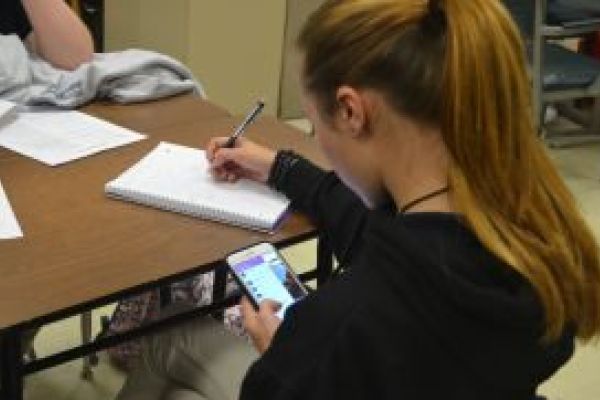 TEENS NEED A CELLULAR DETOX -- Student using phone while she should be working. 