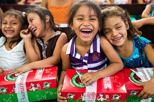 OPERATION CHRISTMAS CHILD GIVES GIFTS TO THOSE IN NEED-- Girls smile as they recieve their shoeboxes.