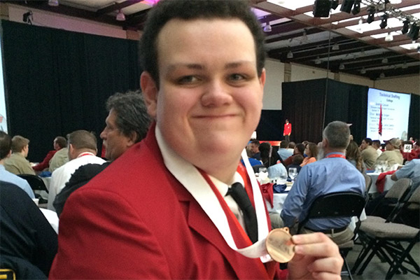 ENGINEERING DESIGN TEAMS BRONZE MEDAL -- James Ortiz, a member of the Engineering Design team, holding their medal.