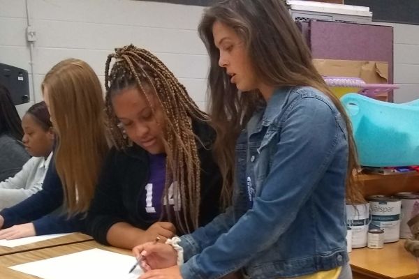 HANNAH GOERING ASSISTS STUDENT -- Goering (right) assists Art 1 student Ariya Meghee (left)