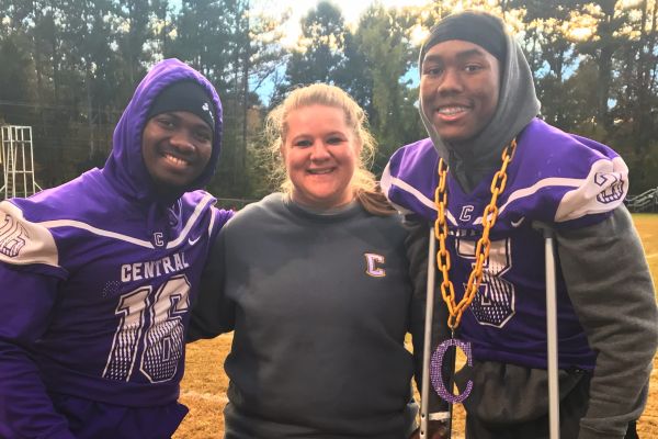 SAMMIE JONES ASSISTS ALL STUDENT ATHLETES THROUGHOUT THEIR SEASON -- (left to right) Senior Michael McGhee, Sammie Jones, and Senior TJ Payne during a recent football game.