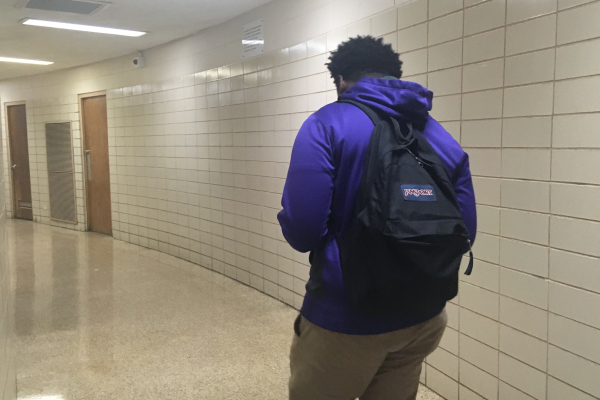 HIGH SCHOOLERS CARRY THE WEIGHT OF THE WORLD ON THEIR SHOULDERS --Senior Lee Melton walks the halls of Central High with his backpack on.