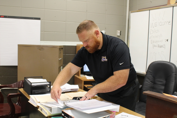 RYAN MALLORY VOLUNTEERS TO BECOME SPONSOR OF THE BETA CLUB -- Mr. Ryan Mallory is pictured organizing his heavy workload while working as the new Beta Club sponsor.