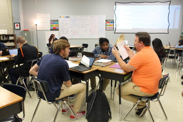 SENIOR CLASS OF 2020  STRIVES TO RAISE GRADUATION RATE -- Senior English teacher Adam Fletcher helps his students get their work done.