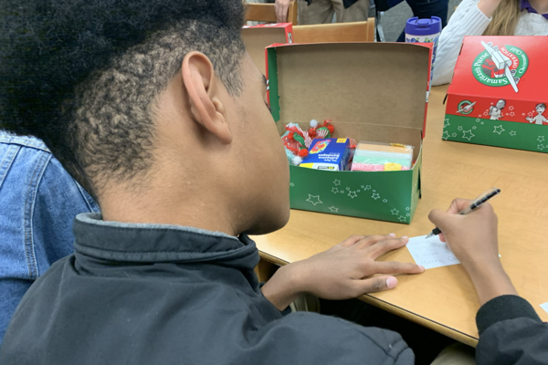 FCA SUPPORTS OPERATION CHRISTMAS CHILD BY COLLECTING GIFT DONATIONS — A student packs a gift box for Operation Christmas Child to spread holiday cheer to less fortunate children.