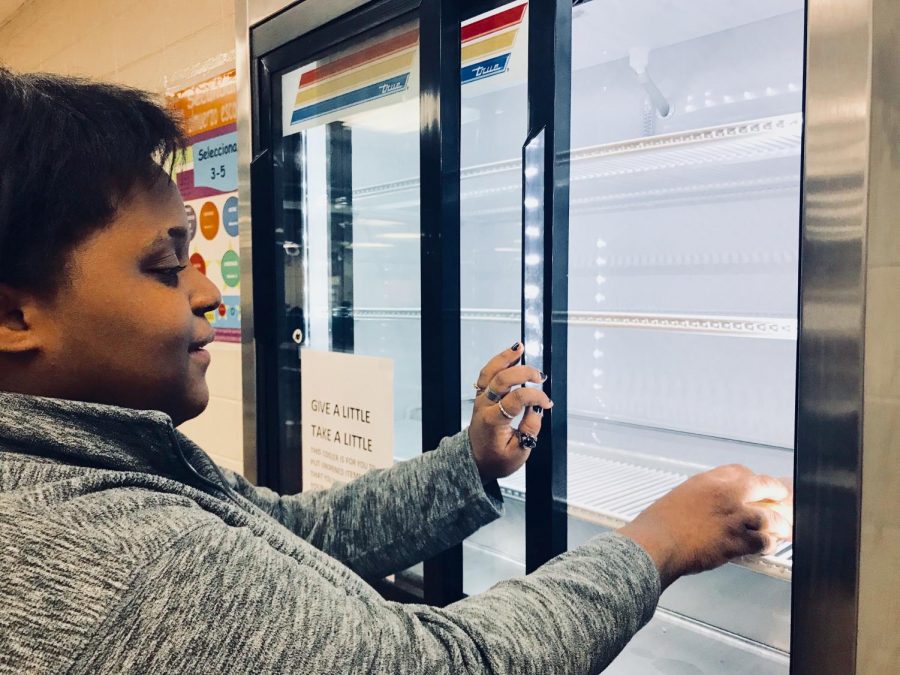 LUNCH LADIES PUT A POSSIBLE STOP TO FOOD WASTE WITH A FREE FOOD PANTRY — Ashauna Parrish places an unopened food item in the designated cooler for another student to enjoy.