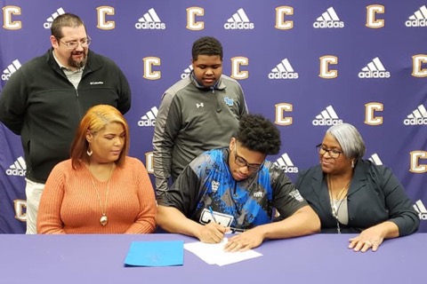 CEDRIC WILLIAMS IS AWARDED SEVERAL SCHOLARSHIP FOR EXCELLENCE IN BOWLING -- Cedric Williams signs alongside his family members and Coach Potter.