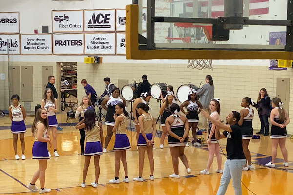 PHYSICAL EDUCATION CONVERTS TO ONLINE LEARNING — Cheerleaders line up to honor senior sports players in the school gym during a pep rally.