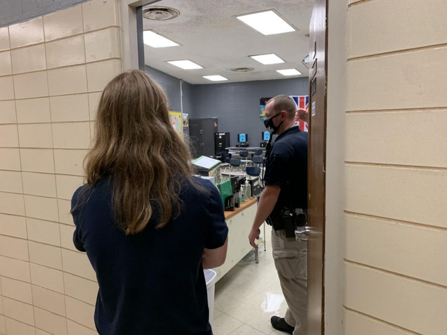 COVID-19 CAUSES LITTLE CHANGE UP IN INTRUDER DRILL -- Officer Marcus Dotson explains intruder drill procedures to a student.