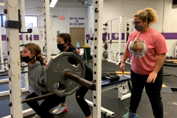 CENTRAL WELCOMES COACHES SHURETTE AND WARE TO SOFTBALL -- Juniors Ashlyn Wood and Calli Morgan work hard in the weight room as Coach Shurette looks on and encourages. 