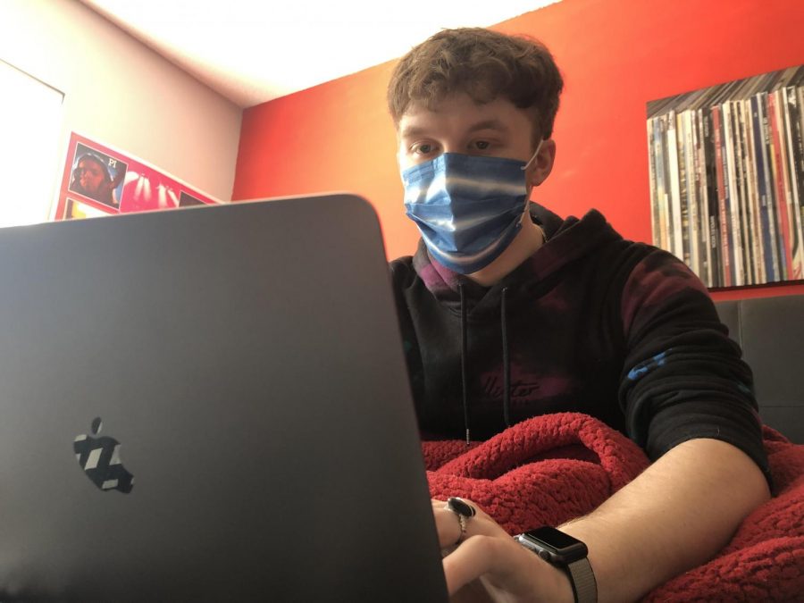 TOPPING 2020 OFF WITH THE CORONAVIRUS -- Senior Columnist Grayson Catlett sits in his bed with a face covering on.