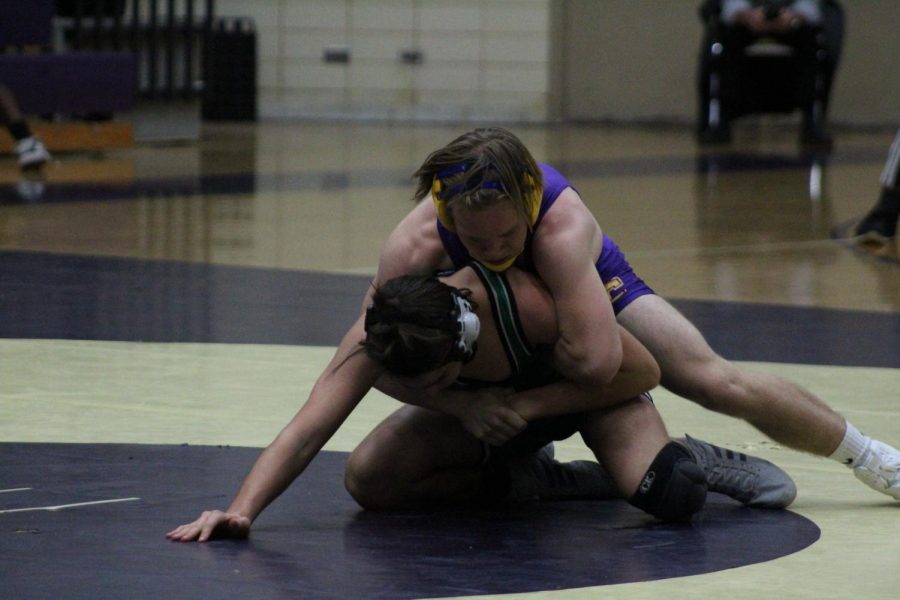 A WRESTLING UPDATE -- Senior Roby Thomas attempts to pin his opponent to the ground.