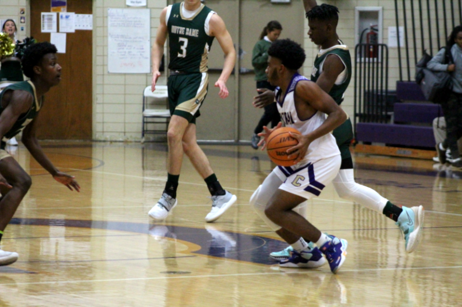 BOYS BASKETBALL TAKES A VICTORY OVER EAST RIDGE -- Junior Ryan Glover fights to keep and run the ball 