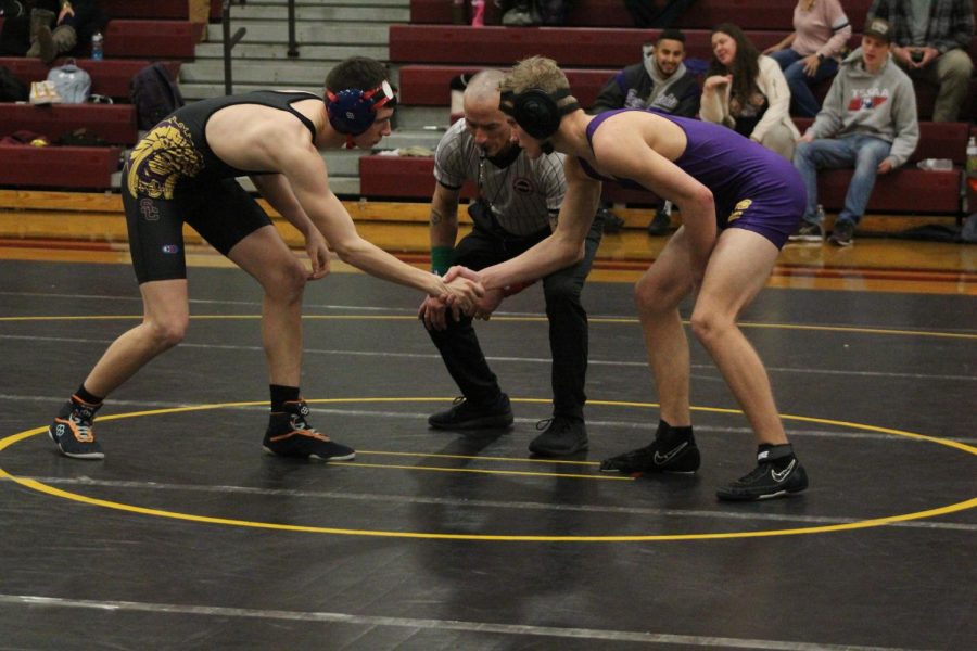 WRESTLING 2021-2022 SEASON GALLERY -- Sophomore, Jesse Fowler shakes hands with his opponent as their match begins.